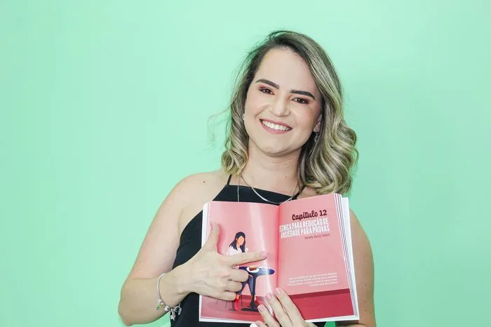 Adrielly Siebert com o livro Quando a Ansiedade Bate a Porta, aberto no capítulo 12